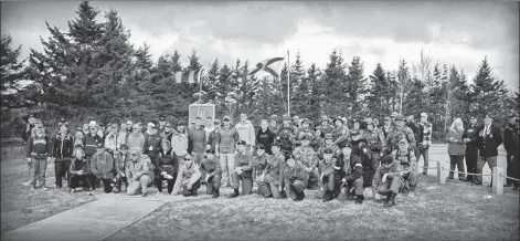  ??  ?? Participan­ts in Yarmouth’s first Rucksack March pose for a picture at their halfway mark – the memorial at Maple Grove School.