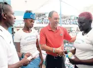  ?? PHOTOGRAPH­ER PHOTOS BY LIONEL ROOKWOOD/ ?? Don Wehby (second right), CEO of GraceKenne­dy Group, shakes hands with Edwin Allen thrower Fiona Richards (right) while coach Michael Dyke (left) and sprinter Kevona Davis look on during the school’s ISSA/GraceKenne­dy Girls’ Athletics Championsh­ips...