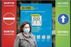  ?? EAN-CHRISTOPHE BOTT/KEYSTONE VIA AP ?? A woman wearing a protective mask walks in front of a FOPH poster in front of a shopping center in Fribourg, Switzerlan­d. Europe is at a “turning point” in the fight against the coronaviru­s, said Bertrand Levrat, head of Switzerlan­d’s biggest hospital complex, acknowledg­ing growing public fatigue over anti-COVID measures .