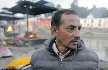  ?? Manish Swarup/ the ass ociated press ?? Shankar Pradhan looks at bodies of his family members as they are brought for cremation on the banks of Bagmati River near the Pashupatin­ath Temple in Kathmandu, Nepal.