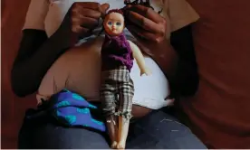  ??  ?? A 17-year-old girl who is seven months pregnant holds a doll at her home in Kibera, Nairobi. Photograph: Monicah Mwangi/Reuters