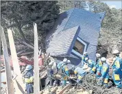  ?? MASANORI TAKEI — KYODO NEWS VIA AP ?? Police search for missing persons around a house destroyed by a landslide after a powerful earthquake in Atsuma on the island of Hokkaido, northern Japan, on Thursday.