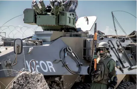  ??  ?? Photo ci-dessus : Le 31 mai 2018, un soldat de la KFOR monte la garde durant l’exercice « Western Blizzard ». Depuis la guerre entre la Serbie et la guérilla indépendan­tiste albanaise, la sécurité du Kosovo est assurée par la Force pour le Kosovo (KFOR). Déployée par l’OTAN en 1999 sur mandat du Conseil de sécurité de l’ONU, elle présentait en février 2018 un effectif de 4031 militaires, provenant de 28 pays. (© KFOR Kosovo)