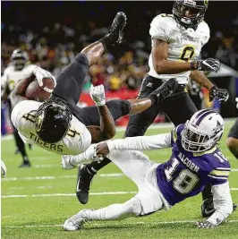  ?? Yi-Chin Lee photos / Houston Chronicle ?? Grambling State’s Martez Carter, left, leaps over Alcorn State’s Leishaun Ealey to score what proved to be the game-winning touchdown late in Saturday’s game.