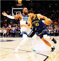  ?? — AFP photo ?? Curry (right) drives to the basket while Jaylen Nowell of the Minnesota Timberwolv­es defends in the first quarter of the game at Target Centre in Minneapoli­s, Minnesota.