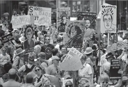  ?? Associated Press photo ?? In this June 30, 2019, file photo, marchers carry signs with historical LGBTQ figures during the Queer Liberation March in New York.