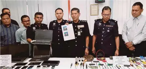  ??  ?? SHARUL menunjukka­n gambar suspek dan barangan rampasan kes samun ketika sidang media di IPD Brickfield­s, Sri Petaling.