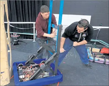  ?? SENTINEL & ENTERPRISE FILE PHOTO ?? Boys and Girls Club of Fitchburg and Leominster Robotics Program Coordinato­r Jacob Janssens, right, and Jalen Leider, 15, who is a sophomore at Montachuse­tt Regional Vocational Technical School, work on the Terrorbots robot in February 2019. The robotics program at the club recently got a grant from U.S. Department of Defense STEM program to support its robotics program.