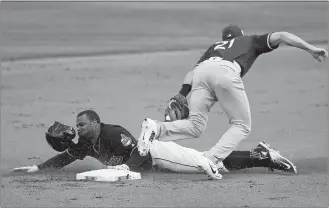  ?? ROSS D. FRANKLIN/AP PHOTO ?? Rajai Davis of the Indians, left, is caught stealing by Athletics second baseman Steve Lombardozz­i (21) in a spring training game on Feb. 27 at Goodyear, Ariz.