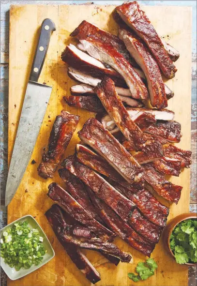  ?? MELINA HAMMER / THE NEW YORK TIMES ?? Try making these Chinese-style barbecued ribs, which were bathed in steam by adding hot water to the roasting pan. The steam treatment produces a texture that is both tender and succulent, unlike the typically gnarled and dry meat that comes from roasting start to finish in an oven or the denatured fare produced by boiling before roasting.