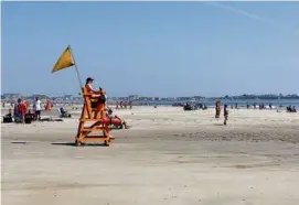  ?? STEVEN PORTER/GLOBE STAFF ?? Lifeguards watched over sunbathers and swimmers at Hampton Beach, N.H., on a hot day in July.