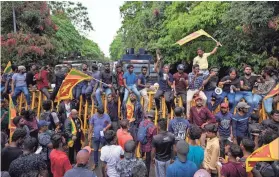  ?? ERANGA JAYAWARDEN­A/AP ?? Sri Lankans demand the resignatio­n of the government in Colombo, Sri Lanka, on Friday. Shops, offices and schools closed and transport came to a near standstill amid nationwide demonstrat­ions against the government over its alleged inability to resolve the worst economic crisis in decades.