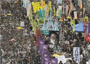  ?? Vincent Yu / Associated Press ?? Protesters carry an image of detained Chinese Nobel Peace laureate Liu Xiabo as they march during the annual pro-democracy demonstrat­ion in Hong Kong. Many say China is violating Hong Kong’s autonomy.