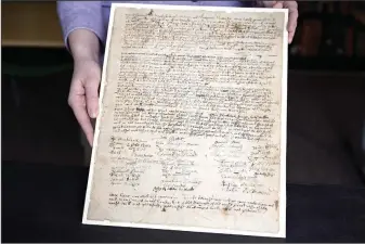  ?? (AP/Jessica Hill) ?? Connecticu­t Historical Society Collection­s Associate Julia Morrow displays on Tuesday an original complaint letter dated to 1669 against Katherine Harrison in Hartford, Conn. Harrison, of Wethersfie­ld, Conn., was tried multiple times for witchcraft.