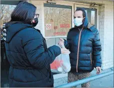  ?? DANA JENSEN THE DAY ?? Client Jasmina Andino, right, talks with Miriaha O’Neil, a social rehabilita­tion specialist of Sound Community Services, after receiving a Thanksgivi­ng meal outside her apartment building Tuesday in New London.