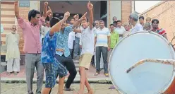  ??  ?? ▪ Villagers dancing to the beats of dhol outside Saurabh`s home in Kaleena.