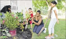  ?? FRAN HUNTER / FOR SMITHVILLE TIMES ?? Ylonda Duncan teaches her children, Steven and Kayilah, how deep to dig holes for the flowers.