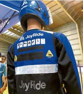  ?? —MEG ADONIS ?? SAFETY FIRST The Joyride PH uniform includes a motorcycle helmet and a vest that shows the rules to be followed by riders.