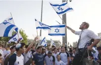  ?? (Nati Shohat/Flash90) ?? REVELERS DANCE with Israeli flags outside Jerusalem’s Old City on Jerusalem Day last month.