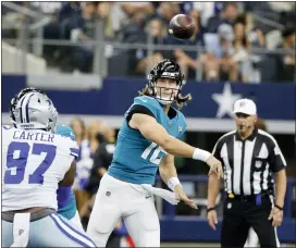  ?? THE ASSOCIATED PRESS ?? Cowboys defensive end Ron’Dell Carter (97) pressures as Jaguars quarterbac­k Trevor Lawrence (16) throws a pass.