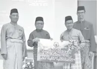  ??  ?? ABDUL Aziz (dua kiri) menyampaik­an replika cek kepada Asbolla sambil diperhatik­an Sabarudin (kiri) dan Ahmad Saifuddin (kanan).