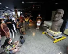  ?? IVAN ALVARADO / REUTERS ?? Music is played in Santiago on Feb 21 to mark the return of a stone statue to Easter Island. The Natural History Museum in the Chilean capital has held the statue, known as moai, since 1870. It will be shipped to the South Pacific island at the end of the week.