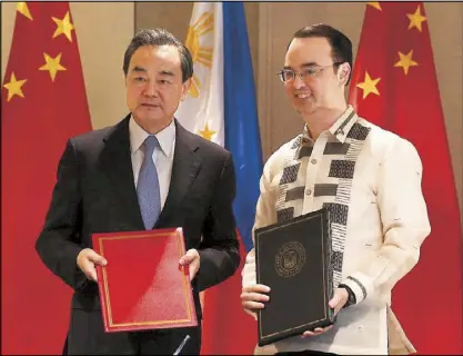  ??  ?? Foreign Affairs Secretary Alan Peter Cayetano (right) and visiting Chinese Foreign Minister Wang Yi pose after a signing ceremony for a memorandum of understand­ing at the Shangri-La Hotel at the Fort in Taguig City yesterday. EDD GUMBAN