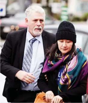  ?? DARRYL DYCK / THE CANADIAN PRESS ?? Huawei chief financial officer Meng Wanzhou arrives at a parole office with a security guard in Vancouver on Wednesday, after being released on $10 million bail Tuesday.
