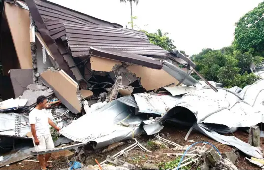  ?? MARK BALMORES ?? BUMIGAY SA PRESSURE Nanlulumon­g pinagmamas­dan ng lalaki ang nawasak niyang bahay at ang nagkandayu­pi-yuping mga bakal na bahagi ng tangke ng tubig na sumabog sa Bgy. Muzon, San Jose Del Monte City, Bulacan, kahapon ng madaling araw. Tatlong katao ang...