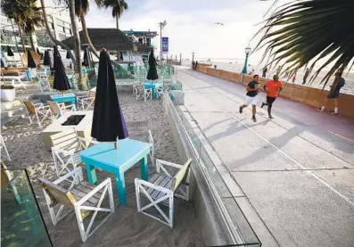  ?? K.C. ALFRED U-T ?? Tables sit empty at the Beach House Grill in Mission Beach on Monday. COVID-19 restrictio­ns prohibit outdoor dining.