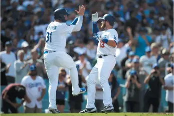  ?? AP PHOTO ?? Max Muncy, right, celebrates his two-run home run with Los Angeles Dodgers teammate Joc Pederson during the fifth inning of a tiebreaker game against the Colorado Rockies on Monday in Los Angeles.