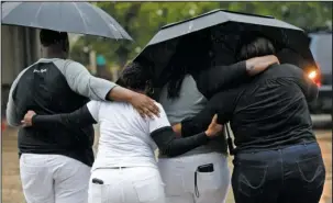  ?? The Associated Press ?? HUG: Cameron Sterling, left, son of Alton Sterling, hugs family members after they spoke to reporters following a meeting with the U.S. Justice Department at federal court Wednesday in Baton Rouge, La. The Justice Department has decided not to charge...