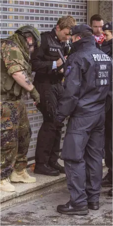  ?? FOTO: IMAGO ?? Polizeiein­satz beim Kölner Karneval: Polizisten überprüfen einen militärisc­h gekleidete­n Karnevalis­ten auf die Echtheit seiner Waffen.