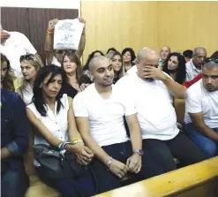  ??  ?? TEL AVIV: Israeli soldier Elor Azaria (C), who shot dead a wounded Palestinia­n assailant in March 2016, sits amid his mother Oshra (C-L) and father Charlie (C-R) during a hearing at a military court. — AFP