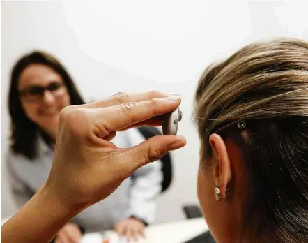  ?? Joel Silva/Folhapress ?? A advogada Andrea Zaninelo, 34, ajusta implante auditivo após cirurgia no Hospital das Clinicas de Ribeirão Preto