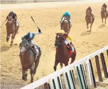  ?? AL BELLO/GETTY IMAGES ?? Jose Ortiz pushes Tapwrit to victory ahead of Irish War Cry with Rajiv Maragh aboard. “The distance, I was sure he could handle it,” Ortiz said.