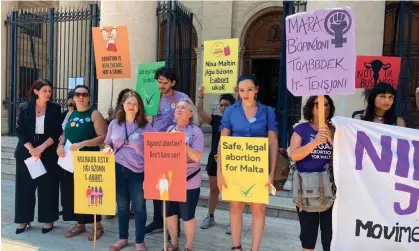  ?? Photograph: Kevin Schembri Orland/AP ?? Activists hold up banners in English and Maltese reading ‘I decide’, ‘Abortion is a woman’s right’, and ‘Abortion is healthcare, not a crime’ outside the country’s courts in Valletta.