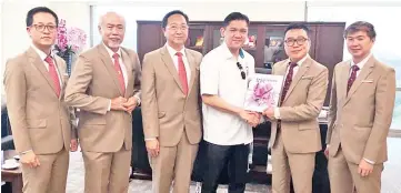  ??  ?? IEM Sabah chairman James Yong Hon Min (second right) presenting a souvenir to Kenny (third right) while Tan Kok Jyh (third left) and other office bearers look on.