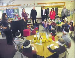  ??  ?? Ken Wagner, Rhode Island commission­er of education, standing third from left, and Woonsocket Superinten­dent Patrick McGee, center, are introduced by School Principal Angela Holt, left, to kindergart­en students and their teacher Tina Elderkin, far left,...