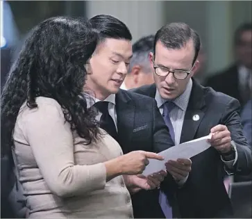  ?? Rich Pedroncell­i Associated Press ?? ASSEMBLYMA­N Evan Low, center, goes over the vote tally sheet for his state constituti­onal amendment with fellow Democratic Assembly members Lorena Gonzalez Fletcher and Marc Berman.