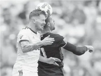  ??  ?? Whitecaps’ Tim Parker, left, and D.C. United’s Sebastien Le Toux go head to head vying for the ball during the first half of their MLS game in Vancouver on Saturday.