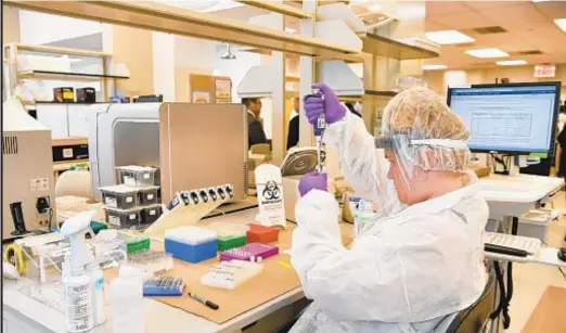  ??  ?? A lab worker transfers solutions from one tube to another at the city Office of Chief Medical Examiner. The office’s missing persons unit handles DNA testing for unidentifi­ed people as well as victims of disaster events.