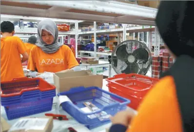  ?? DARREN WHITESIDE / REUTERS ?? An employee at online retailer Lazada fills an order at the company’s warehouse in Jakarta, Indonesia.