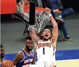  ?? ELSA/GETTY IMAGES ?? Devin Booker (1) of the Suns celebrates his dunk in the third quarter against the Knicks at Madison Square Garden in New York City on Monday.