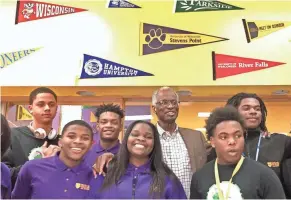  ?? JOHN SCHMID / MILWAUKEE JOURNAL SENTINEL ?? Howard Fuller (rear, second from right), founder of the Milwaukee Collegiate Academy, festooned the hallways of his school with pennants and flags from colleges around the nation. The school’s mission is to get kids “to and through college.”