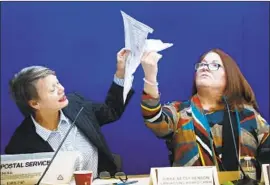  ?? Wilfredo Lee Associated Press ?? CANVASSING BOARD chair Judge Betsy Benson, left, and board member Judge Deborah Carpenter-Toye hold a damaged ballot in Lauderhill, Fla.