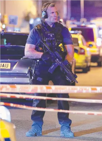  ?? Picture: PA via AP ?? An armed police officer stands guard near the scene of the attack in London.