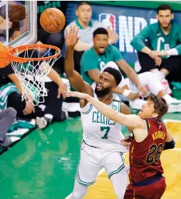  ??  ?? BOSTON CELTICS guard Jaylen Brown (7) scores two of his game-high 23 points in front of Cleveland Cavaliers defender Kyle Korver during the Celtics’ 108-83 home victory over the Cavs in Sunday night’s Game 1 of the Eastern Conference finals.