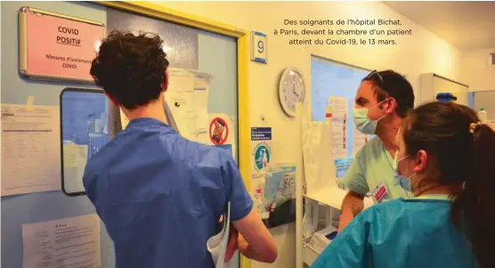  ??  ?? Des soignants de l’hôpital Bichat, à Paris, devant la chambre d’un patient
atteint du Covid-19, le 13 mars.