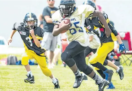  ?? SUPPLIED PHOTO ?? Niagara Titans back Sacade Kasamba, with the ball, on his way to scoring one of his three touchdowns versus West Niagara in bantam football Sunday in Smithville.